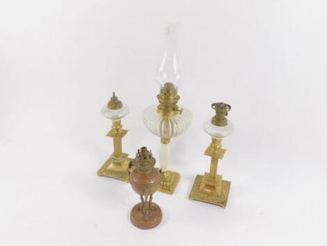 A pair of brass oil lamps of squat candlestick form