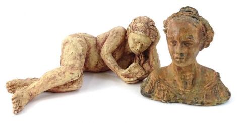 A terracotta sculpture of a reclining nude female reading