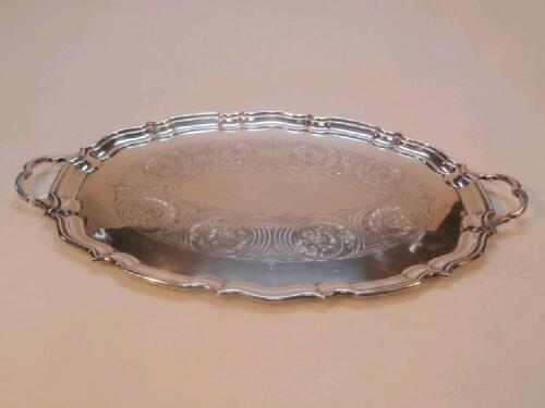 An electroplated oval serving tray with everted rim and two handles and