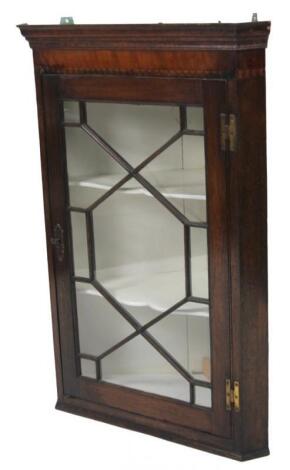 An early 19thC oak and mahogany hanging corner cupboard