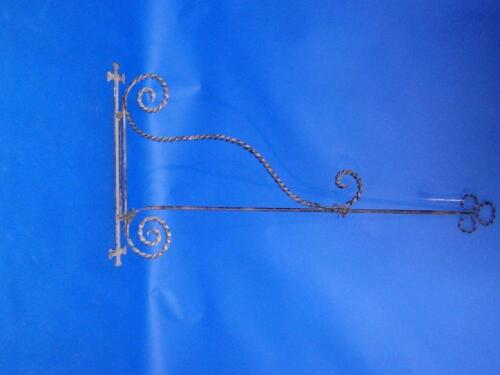 A wrought iron sign bracket with spiral trefoil terminal and similar supports
