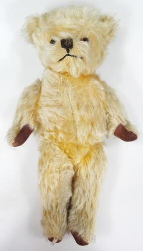 A blonde plush jointed Teddy bear.