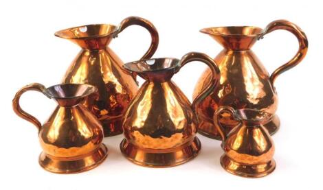 A set of various copper measuring jugs