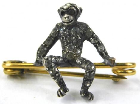 A silver white stone set seated monkey