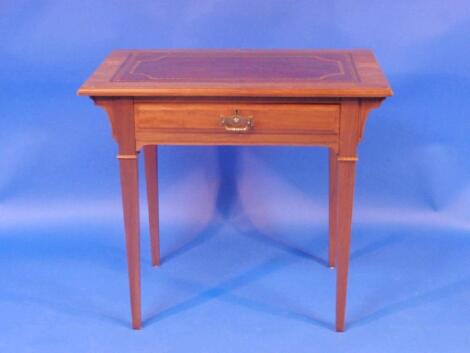 An Edwardian walnut writing table with leather inset top