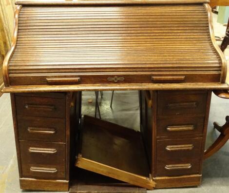 An early 20thC oak roll top desk