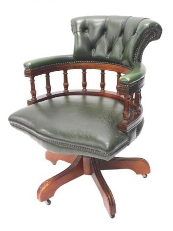 A green leatherette swivel office chair