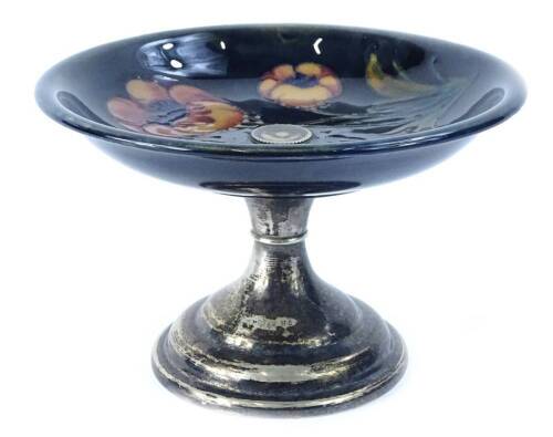 A Moorcroft pottery Big Poppy pattern comport or tazza, on a mottled navy blue ground, impressed mark to underside and silver plated pedestal and foot, 12cm H, 18.5cm diameter.