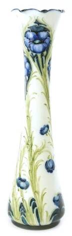 A MacIntyre & Co Moorcroft Florian ware vase, decorated with a poppy design, in blue and green, on a cream ground, the waisted vase with a petallated border, 31cm H.