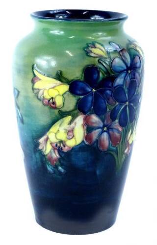 A Moorcroft pottery Spring Flowers pattern vase, decorated with flowers on a mottled blue and green ground, impressed and hand written initials to underside, 21cm H (AF).