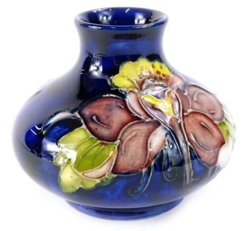 A Moorcroft Columbine pattern squat vase, decorated with flowers on a cobalt blue ground, impressed mark to underside, 7.5cm H.