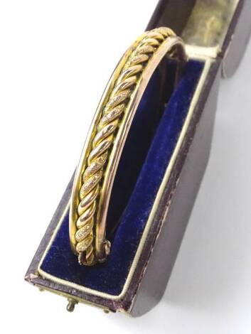 A 9ct gold hinged bangle, of pleated twist design, with two outer border, with E Gregory of Loughborough box, 10.5g all in.