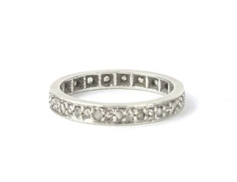 An eternity ring, set with various tiny white stones, in a white metal setting, possibly silver, unmarked, 2.2g all in.