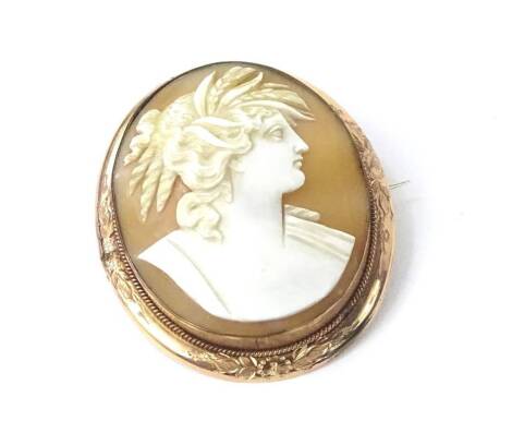 A large cameo brooch, in gilt metal border, the cameo of a lady looking right, with bunched curly hair, with floral scroll design border, the cameo 3.5cm W x 4cm H.