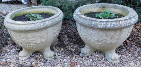 A pair of composition garden urns or planters, each cast with leaves on paw feet, 59cm diameter.