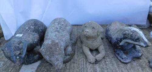 Four composition garden ornaments, three modelled in the form of badgers and a puppy.