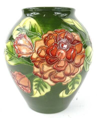 A Moorcroft Camellia pattern vase, decorated with flowers and leaves, on a green ground, designed by Debbie Hancock, No. 27 of 33, hand signed and impressed mark to underside, 21cm H.