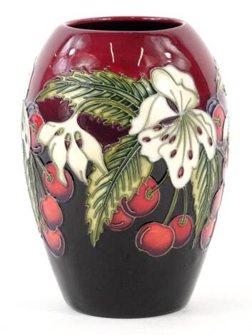 A Moorcroft pottery bullet shaped vase, decorated with a band of flowers, cherries etc., trial piece dated 21.11.12, 13cm H.