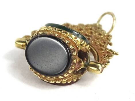 A gilt metal and agate swivel fob, the fob three sided, with blue, green and orange agate, on heavily floral scrolled gilt pendant.