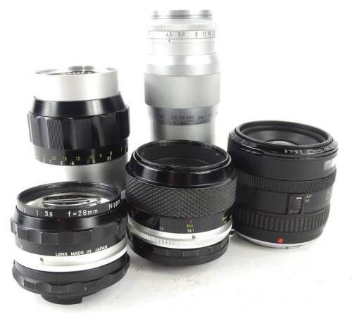 A collection of camera lens, to include a Nikon 135mm, a Nikon 55mm, a Canon 70mm, and a 135mm lens.