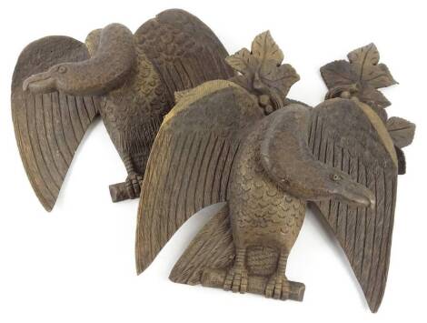 Two similar carved oak Black Forest type eagles, each with a grape and vine cresting, (AF), 21cm W.