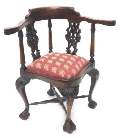 A mahogany corner chair, with two pierced carved splats, a padded seat on cabriole legs with ball and claw feet. The upholstery in this lot does not comply with the 1988 (Fire & Fire Furnishing) Regulations, unless sold to a known exporter or upholstere