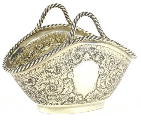 A Victorian silver basket, with two stylised rope twist handles and border, embossed with scrolls, surrounding two vacant cartouches, Sheffield 1881, 5oz, 13cm W.