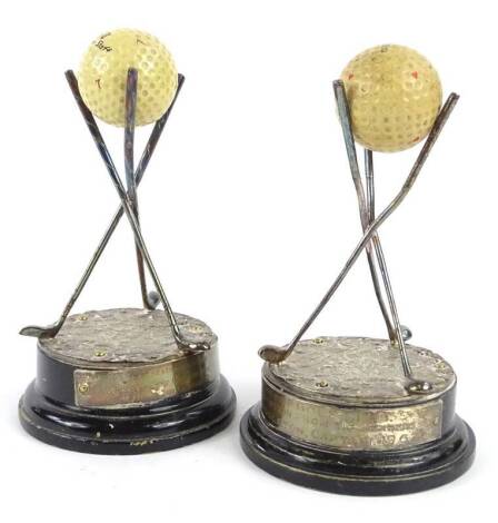 A pair of silver plated golf trophies, each modelled in the form of three clustered clubs, on naturalistic base, mounted with a loose ball on ebonised foot, 16cm H.