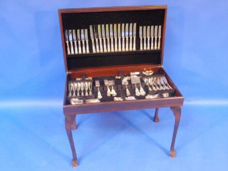 A modern mahogany finished cutlery cabinet on cabriole legs fitted with