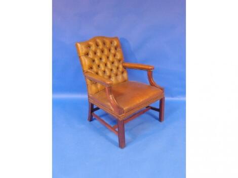 A mid 20thC mahogany framed Gainsborough chair upholstered in buttoned leather