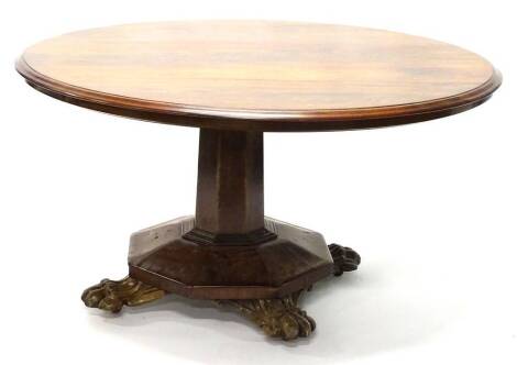 A William IV mahogany breakfast table, the circular top with a moulded edge, on an octagonal column and platform with carved paw feet, 123cm diameter.