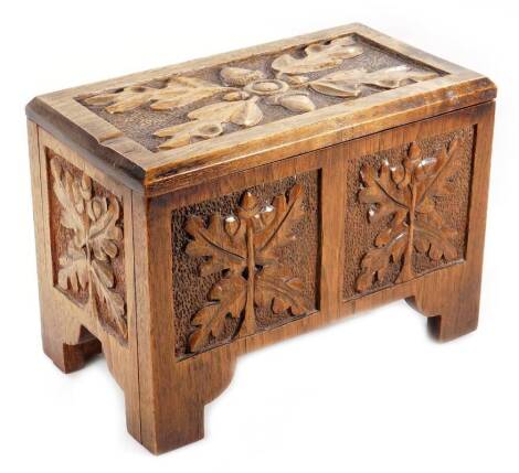 A 19thC miniature oak coffer, of rectangular form, the hinged lid carved with acorns and leaves, with a plain interior and a panelled front, on block stiles, 20cm H, 28cm W, 16cm W.