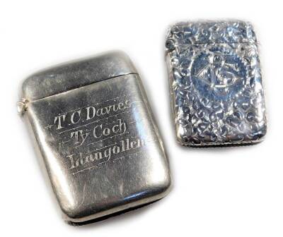 An early 20thC silver vesta case, of rounded form, chased, with match strike base and initialled front, marks rubbed, 4.5cm H, and a further plated vesta case. (2)