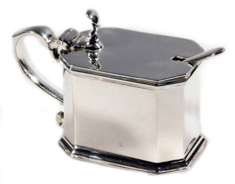 A George VI Scottish silver mustard pot, of canted rectangular form, with thumb mould leafy S scroll handle and shaped body, Edinburgh 1938, 7cm H, 3½oz, with blue glass liner and associated spoon.