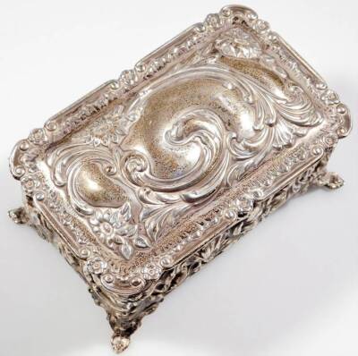 An Edwardian silver casket, of rectangular form, repousée decorated and heavily raised with scrolls and flowerheads, with a plain interior, on shaped feet, Birmingham 1905, 12cm W, 4oz. - 2