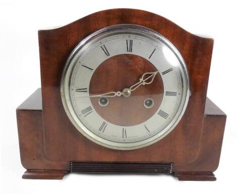 A 1950s walnut cased 8-day mantel clock, the 14cm Dia. Roman numeric dial with two winding holes revealing a keywind movement in a shaped case, 22cm H.