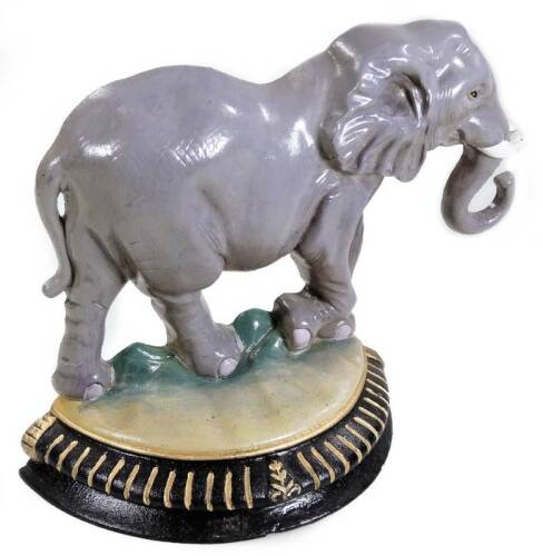 A 20thC cast metal elephant doorstop, painted grey on a D shape gilt highlighted base, 27cm H.