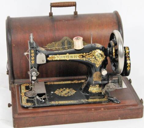 An early 20thC Singer sewing machine, in domed case, with articulated handle, 43cm W.