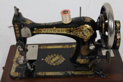 An early 20thC Singer sewing machine, in domed case, with articulated handle, 43cm W. - 2
