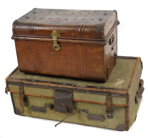 An early 20thC tin trunk, the domed top partially studded, with a plain interior, 37cm H, 55cm W, 37cm D and a travel case with stitched leather border, leather carrying handles and a pressed body initialled A A L. (2)