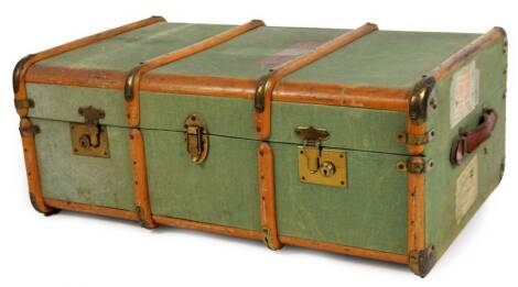 An early 20thC travel trunk, partially wooden and metal bound with pressed green material and luggage labels, 33cm H, 79cm W, 54cm D.