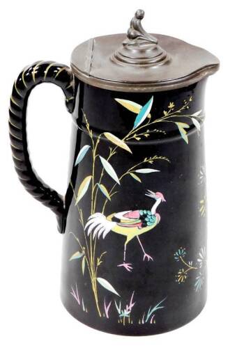 A 19thC oriental design jug, with pewter lid, the cylindrical tapering body decorated with exotic bird and flowers, with C scroll rope twist handle, unmarked, 26cm H.