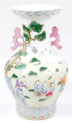 A Chinese porcelain famille rose baluster vase, with compressed trumpet stem, shaped handles and bulbous body, heavily decorated with children playing blind man’s buff, with mountains and trees in the distance, predominately in pink, purple and green, on - 3
