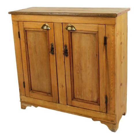 A 20thC pine cupboard, with over hanging plank top, raised above a double cupboard, on shaped feet, 95cm H, 95cm W, 36cm D.