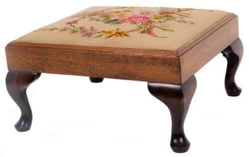 An oak framed footstool, the square top with drop in petit point floral seat, on compressed cabriole club legs, 23cm H, 45cm W, 45cm D.