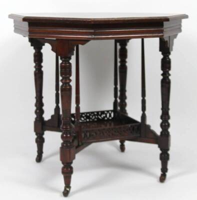 A Edwardian walnut window table, the octagonal top raised on turned legs, joined by a galleried undertier and raised on castors, 74cm H, 73cm W, 75cm D.