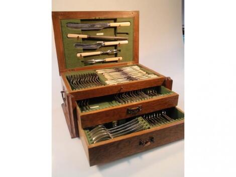 AN early 20thC oak canteen containing a near complete suite of old English cutlery