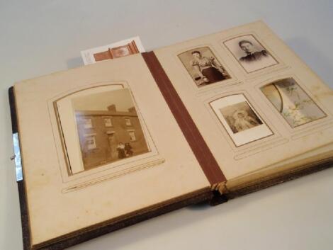 An early 20thC photograph album with chronolithographic papers in embossed leather boards