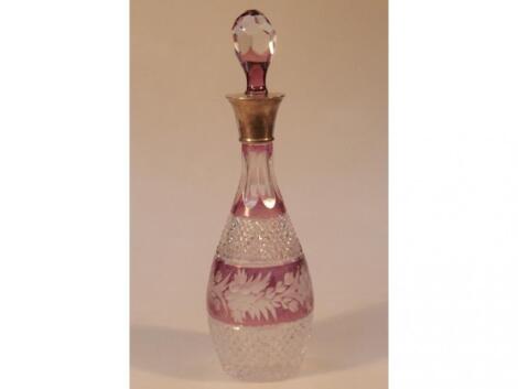 A purple tinted cut glass decanter with silver collar