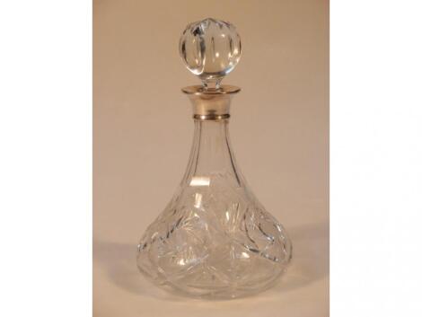 A cut glass ship's decanter with a silver collar